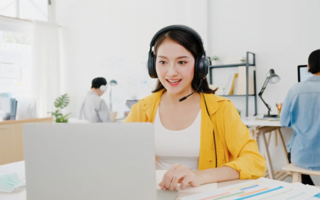 Contact Center Agent senyum melayani customer dengan menggunakan headphone